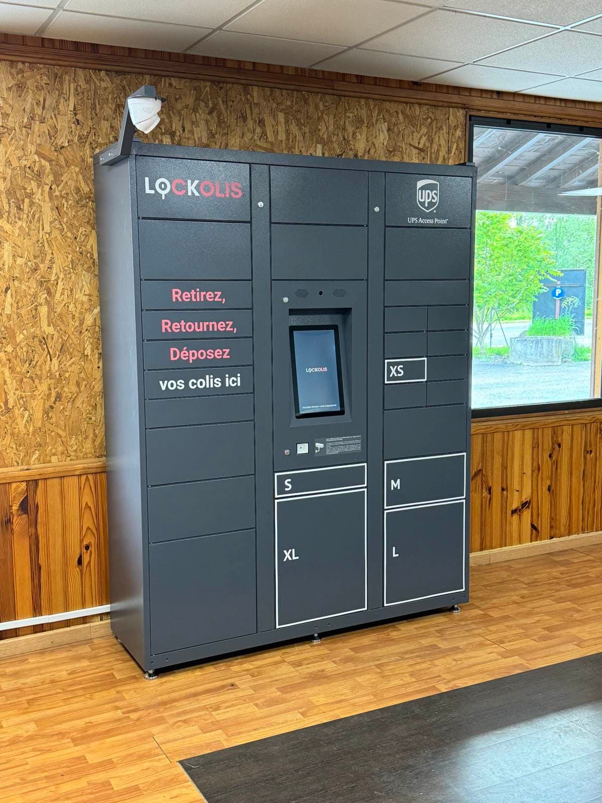Casier Lockolis du réseau, marqué UPS Access Point, installé dans un commerce : « Retirez, retournez, déposez vos colis ici »