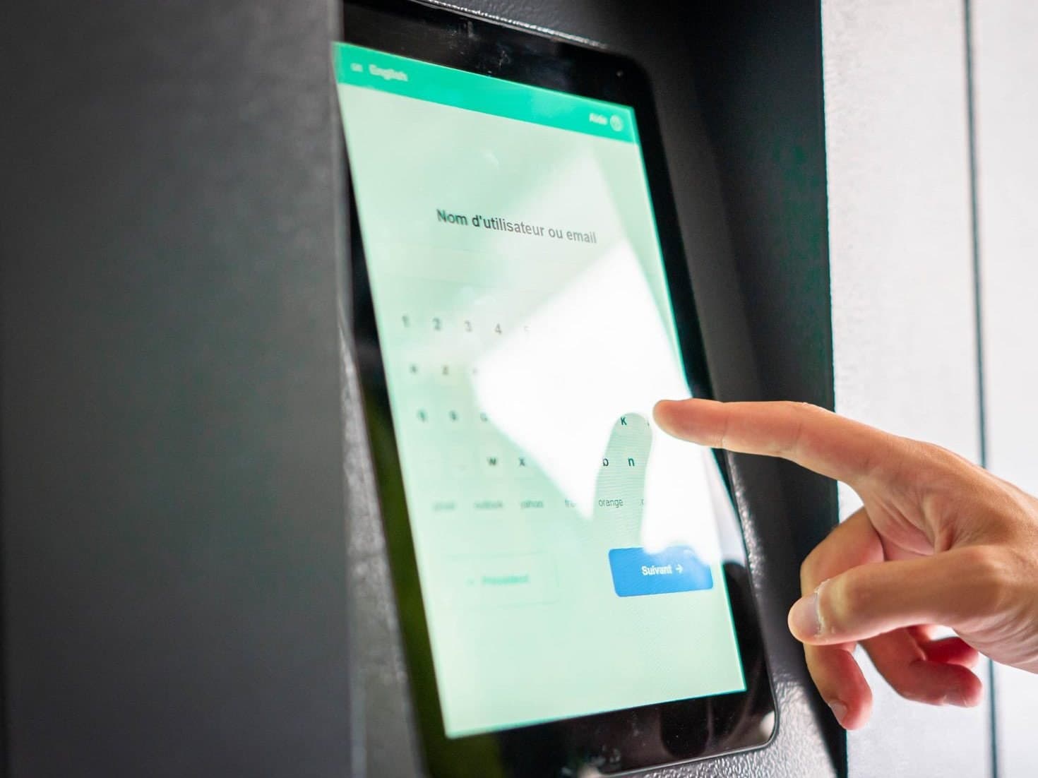 Close-up of a finger touching the touchscreen of a Lockolis smart locker